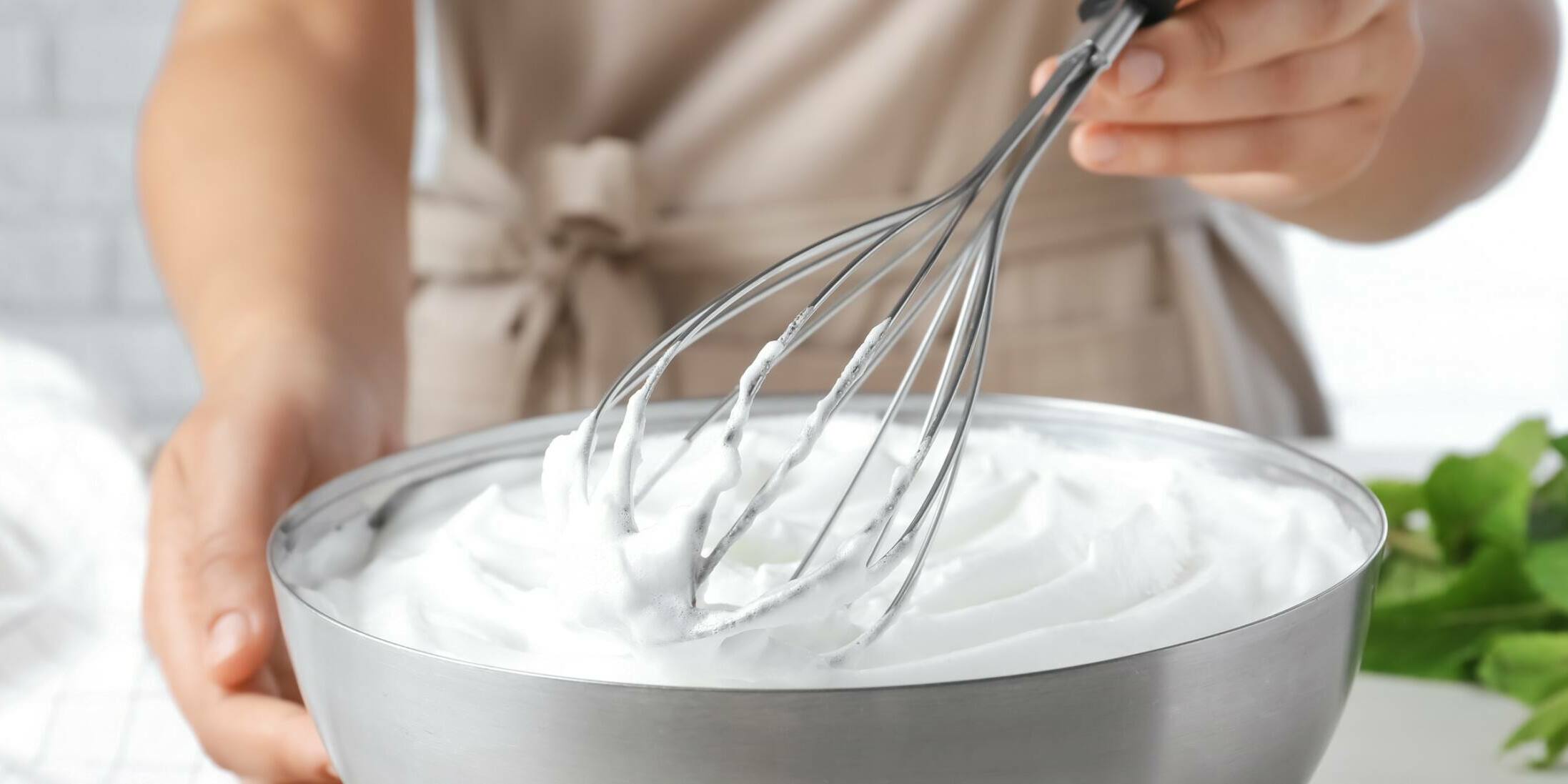 Nata para montar Mujer montando nata con unas varillas
