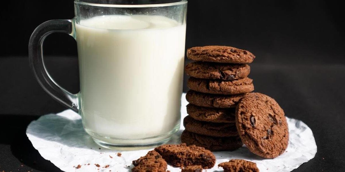 leche-soja-galletas Un vaso de leche de soja con galletas.