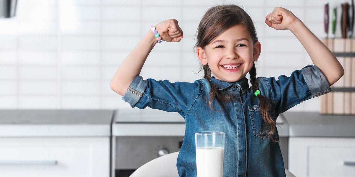 Niña con un vaso de leche.