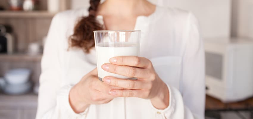 Mujer sujetando un vaso de leche.