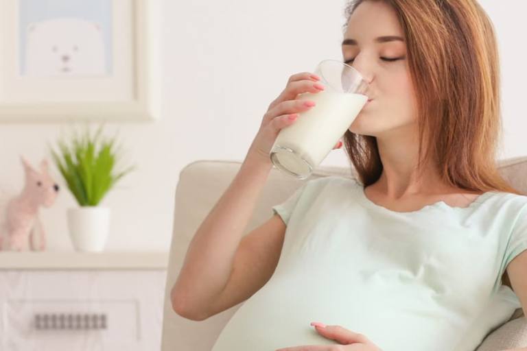 Embarazada tomando un vaso de leche.