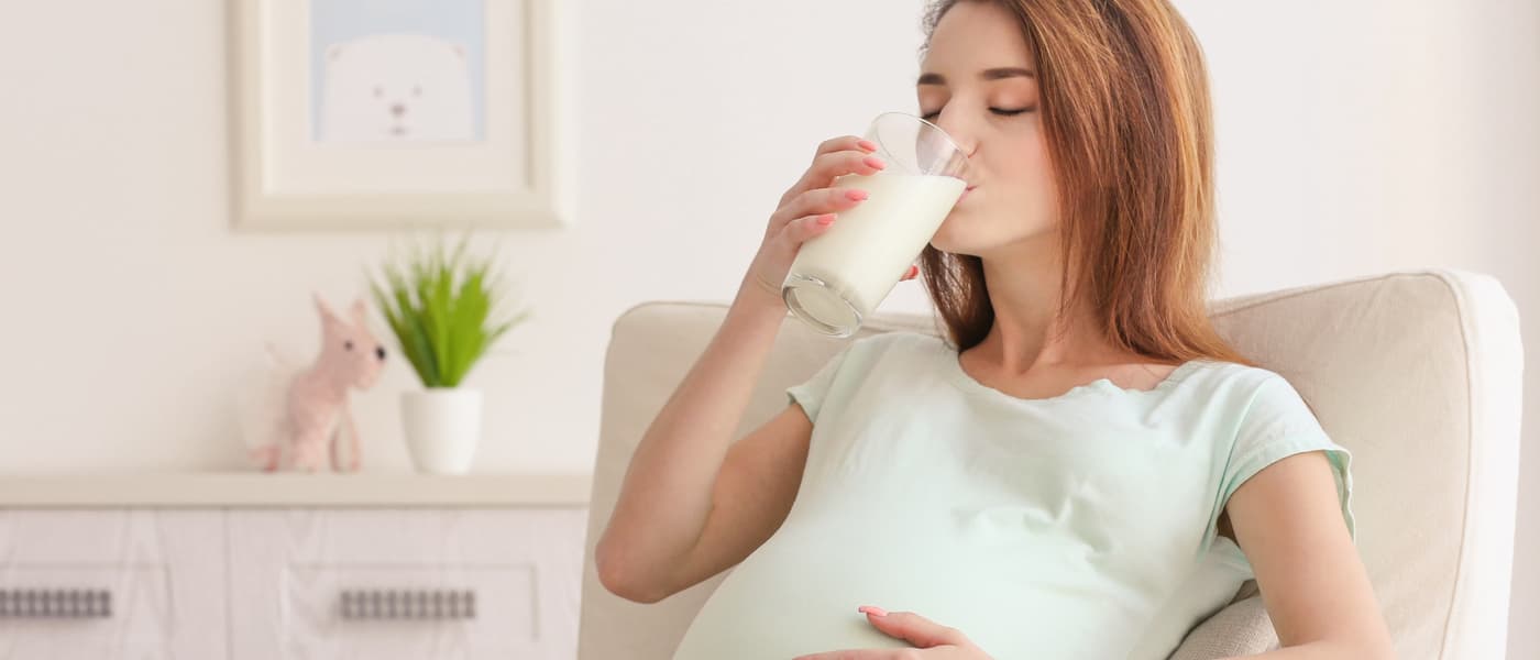 Embarazada tomando un vaso de leche.