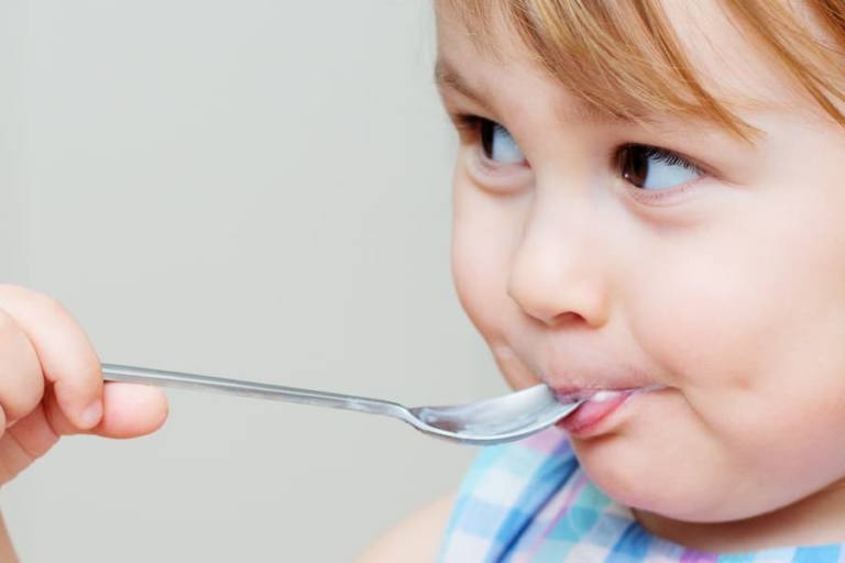 Niña comiendo un yogur.