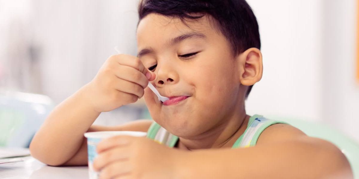 nino-comiendo-yogur Niño comiendo un yogur.