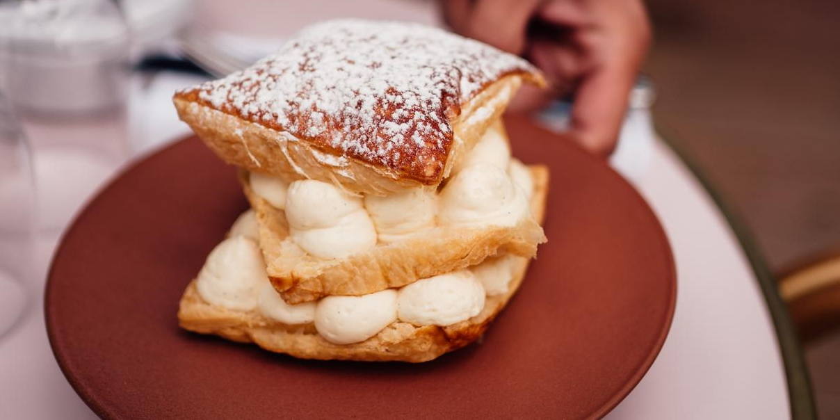 milhojas-de-nata Las milhojas de nata son un pastel tradicional que combina capas crujientes de hojaldre con tierno relleno.